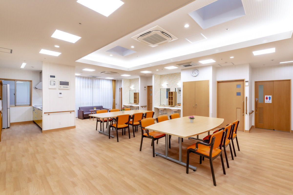 天窓から自然の光が降り注ぐ明るいデイルーム。